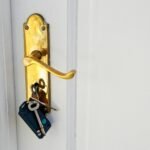Golden doorknob with keys on a white door